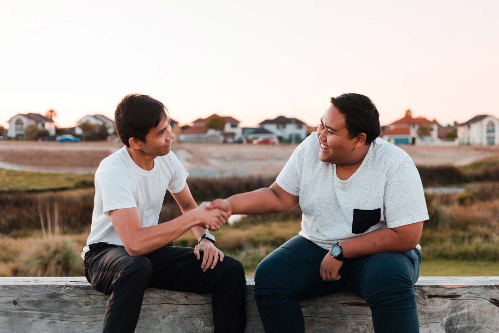 Two young Asian man come to an agreement at the park.