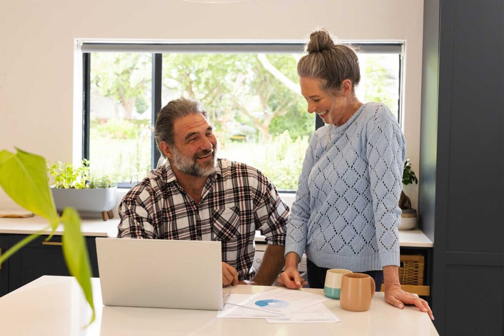 Couple looking at laptop in kitchen