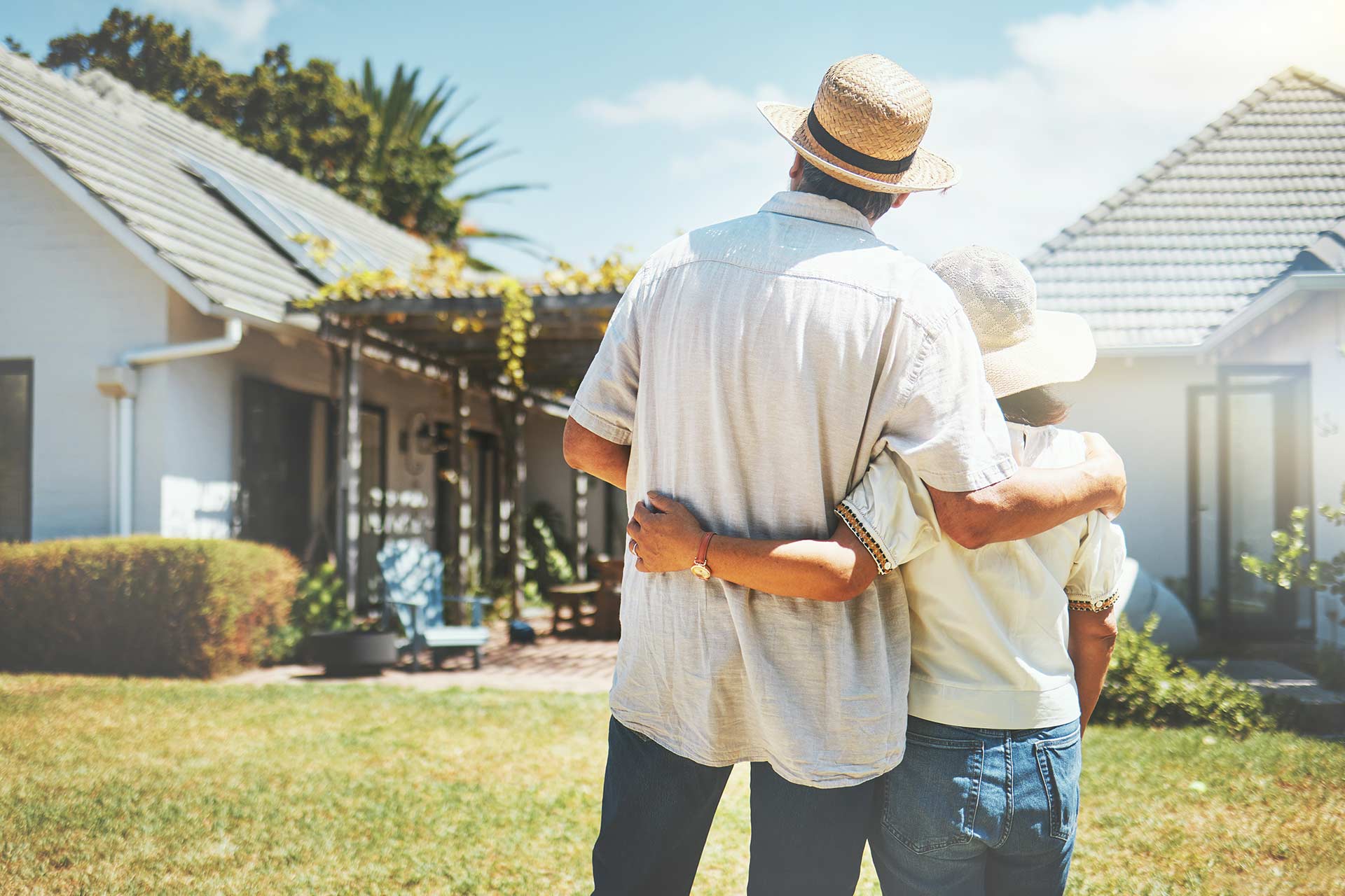 back view of couple hugging while looking at home