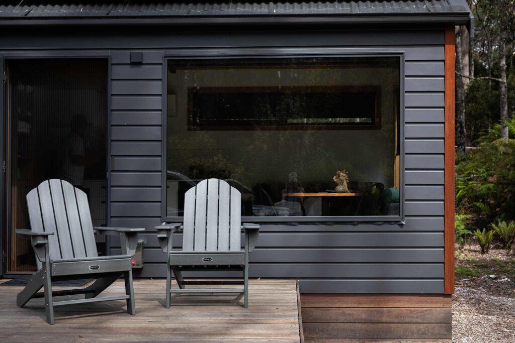 Chairs on porch of small grey home