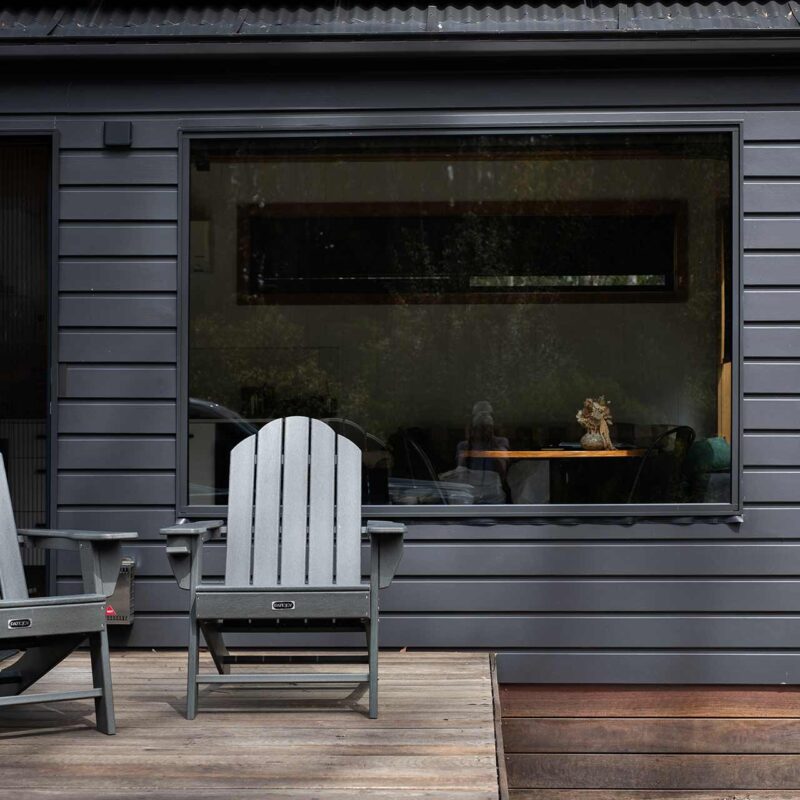Chairs on porch of small grey home
